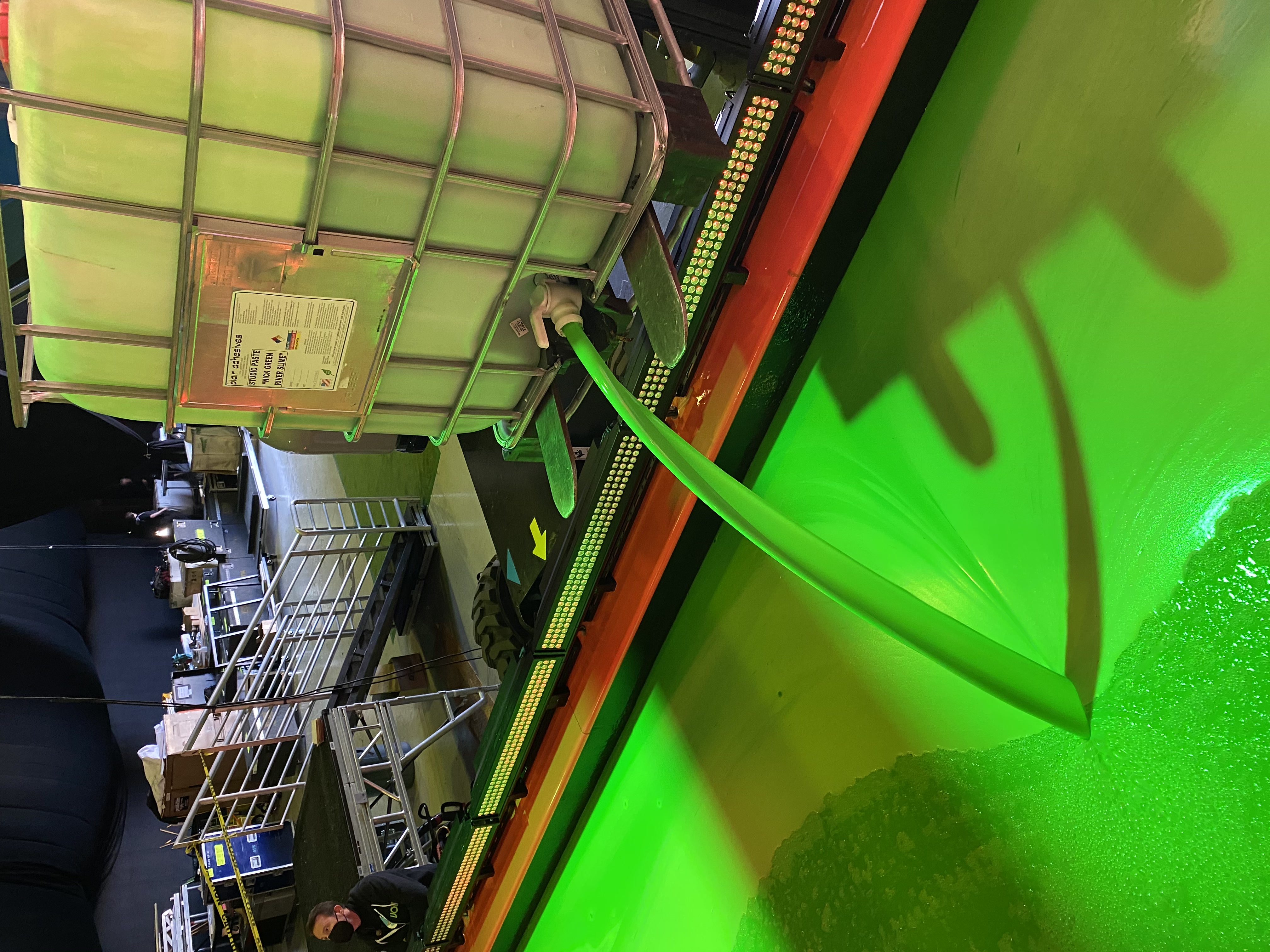 Industrial tote bin containing bright green slime material